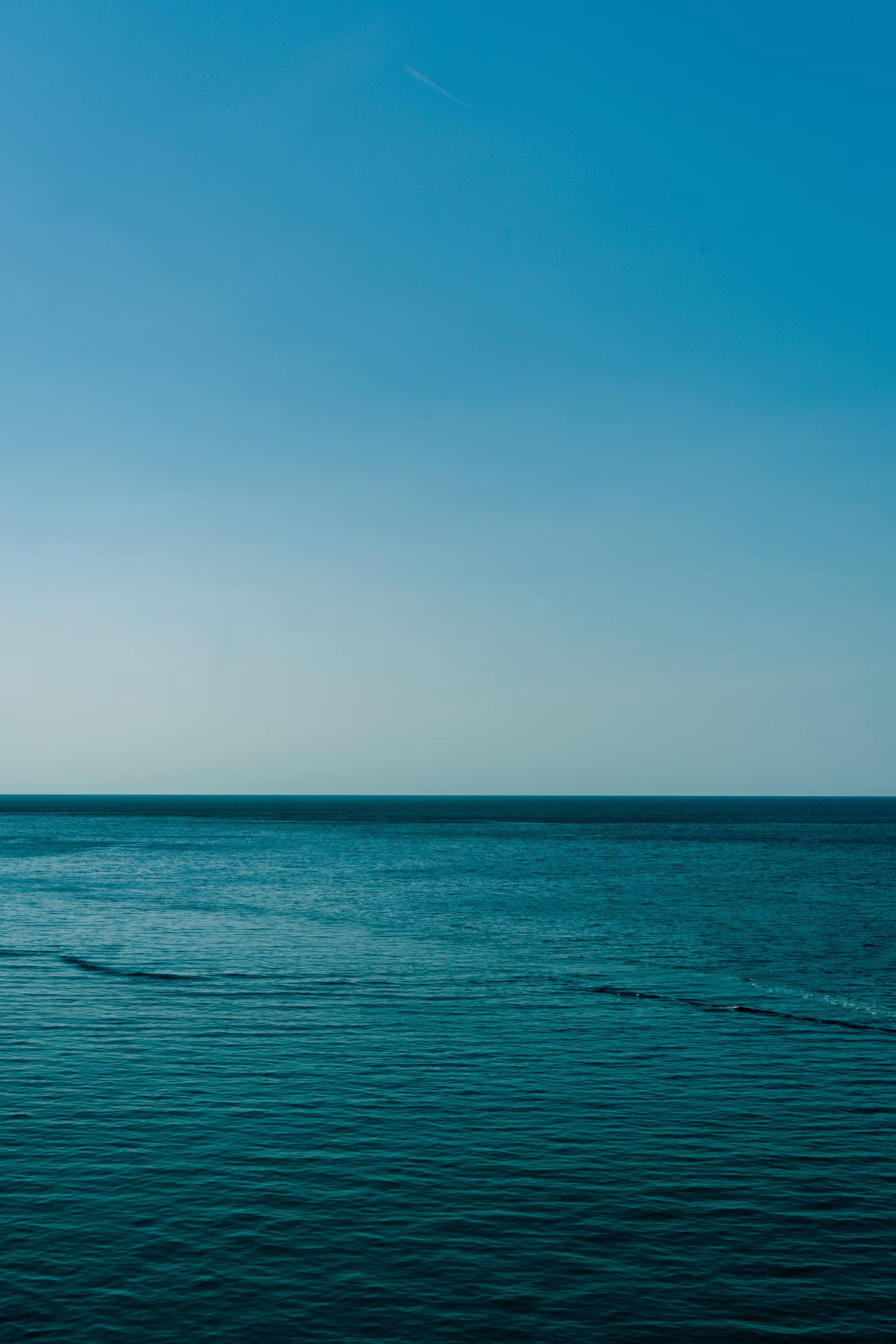 Weite über einem ruhigen blauen Meer. Naturfotografie von Lucas Klein.